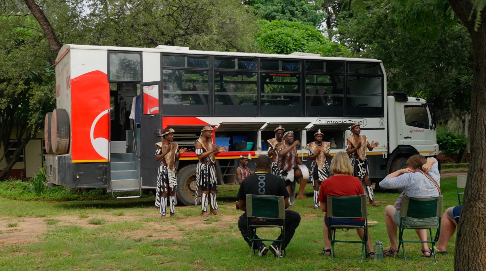 Traditional dancers performing beside an overland truck at Rest Camp